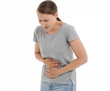 image of a lady holding her stomach in pain
